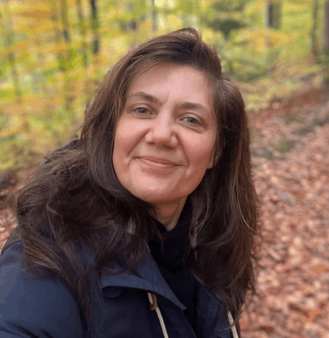 Yvy im Wald in die Kamera lächelnd